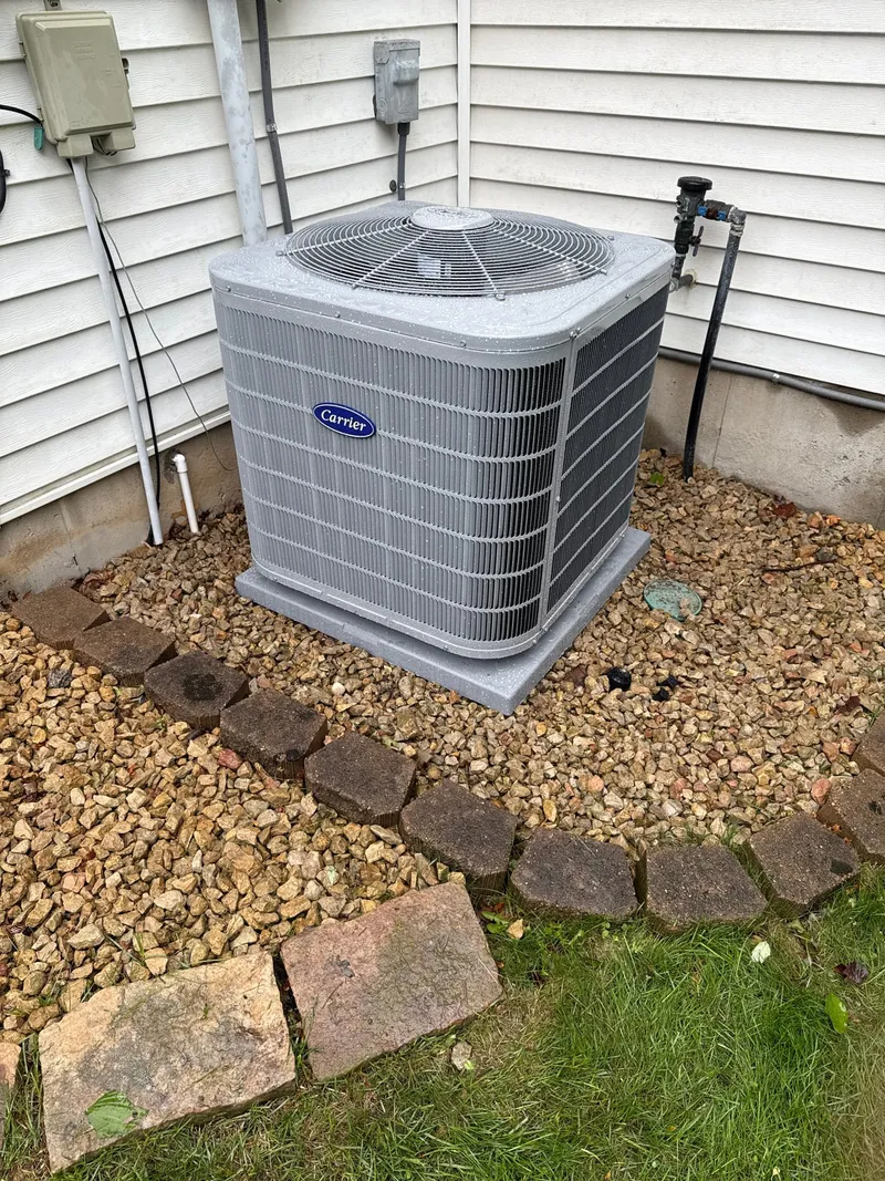 Carrier outdoor air conditioner condenser beside house siding