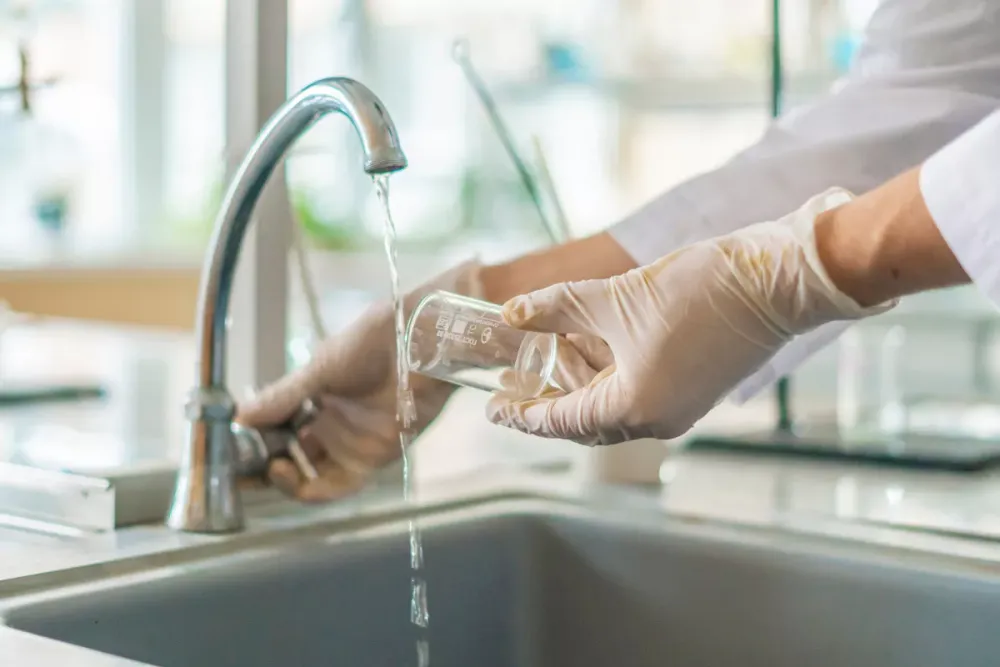Collecting a tap water sample for testing