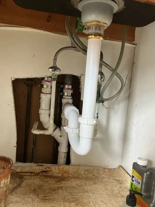 Drain strainer and PVC pipe beneath a kitchen sink