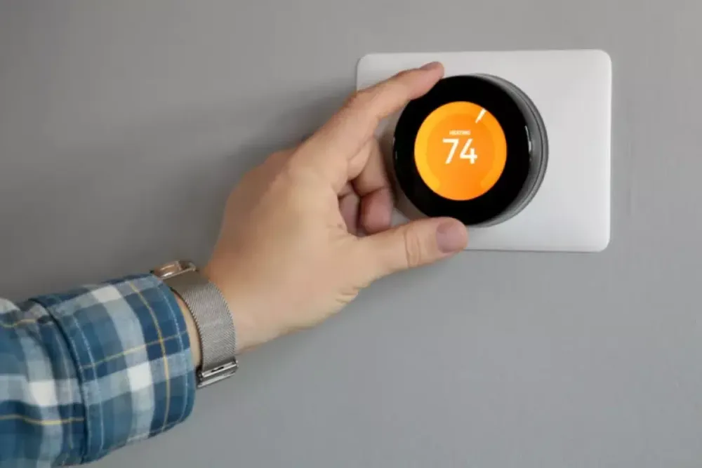 Hand adjusting a round smart thermostat