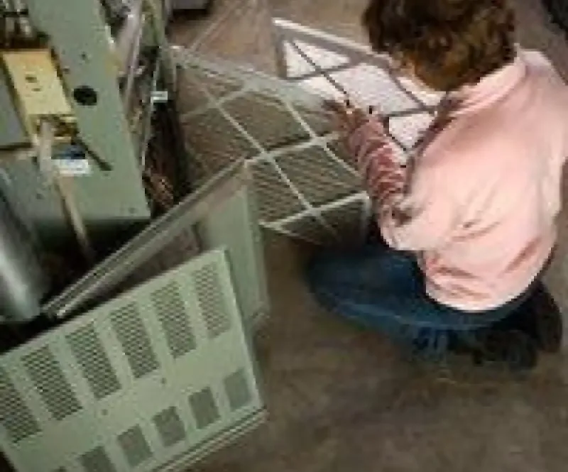 Homeowner removing a furnace air filter
