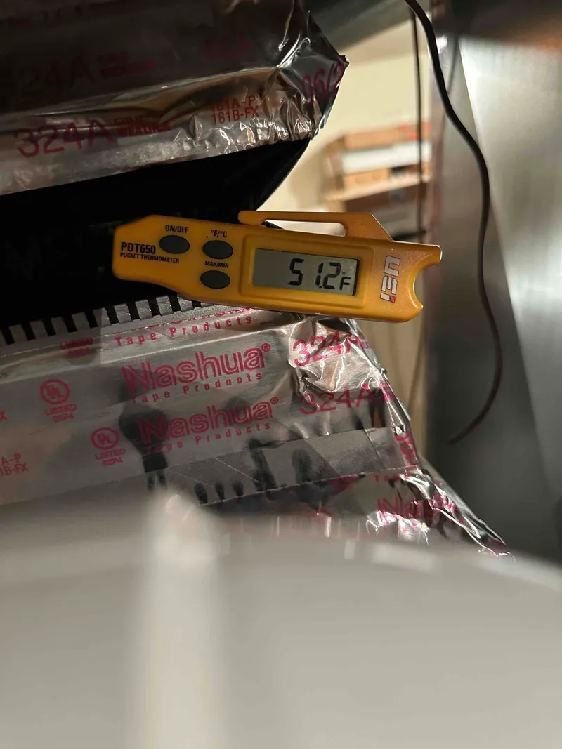 Digital thermometer measuring air temperature inside HVAC ductwork