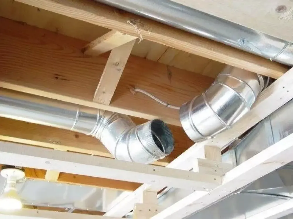 Metal air ducts running between ceiling joists