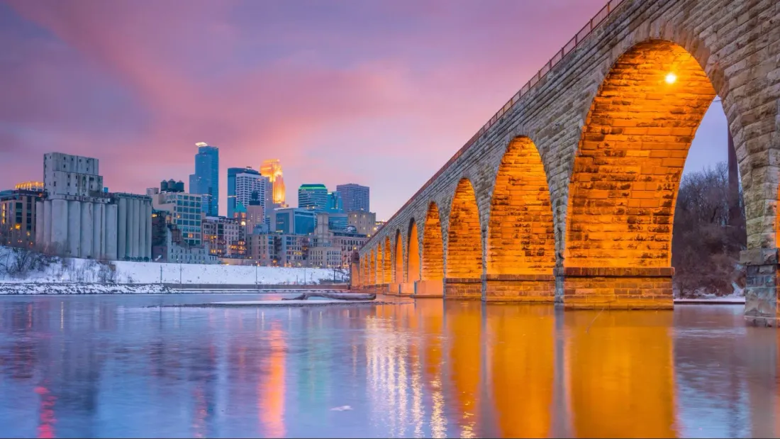 Stone Arch Bridge and the Minneapolis skyline at sunset in winter