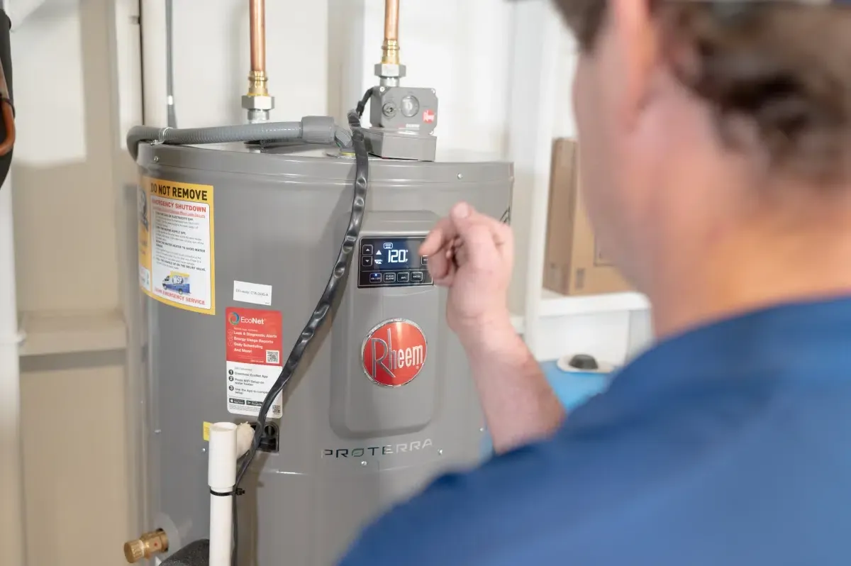 MSP technician adjusting controls on a Rheem water heater