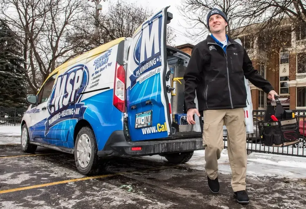 MSP technician beside a service van in winter