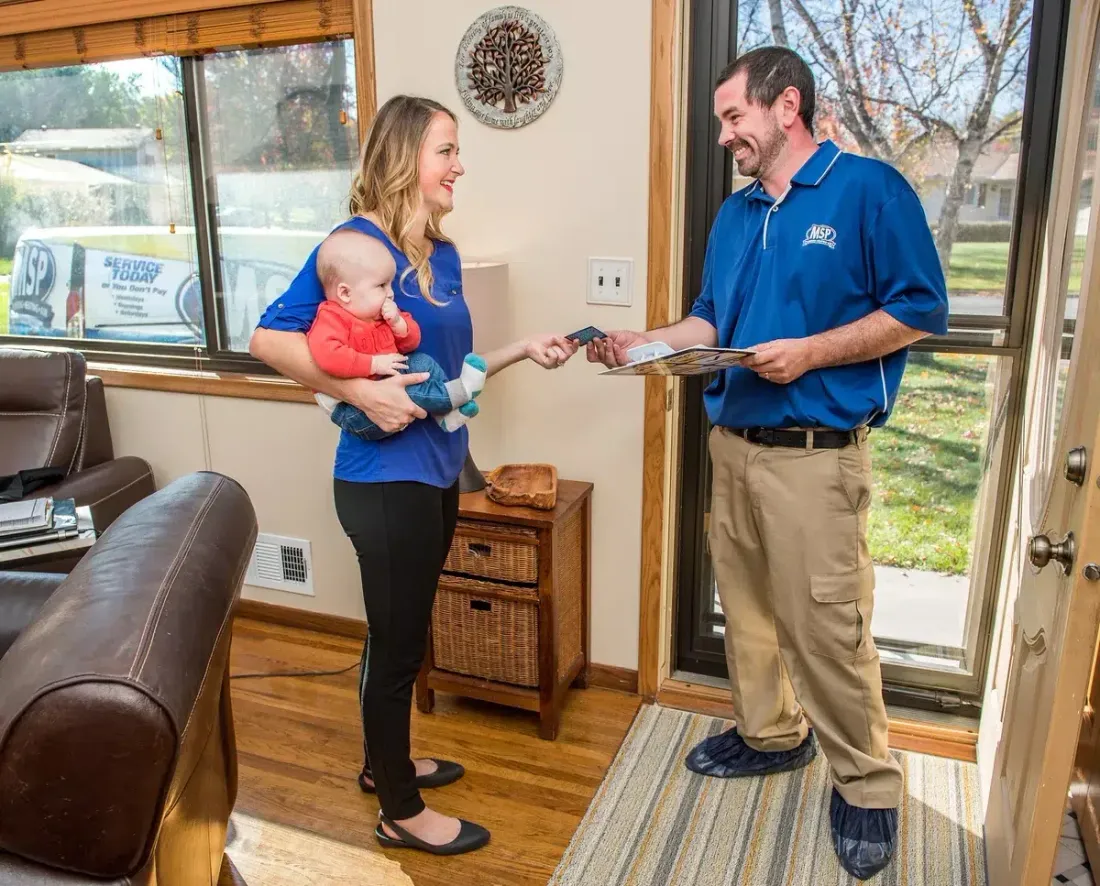 MSP technician discussing service with a homeowner and child