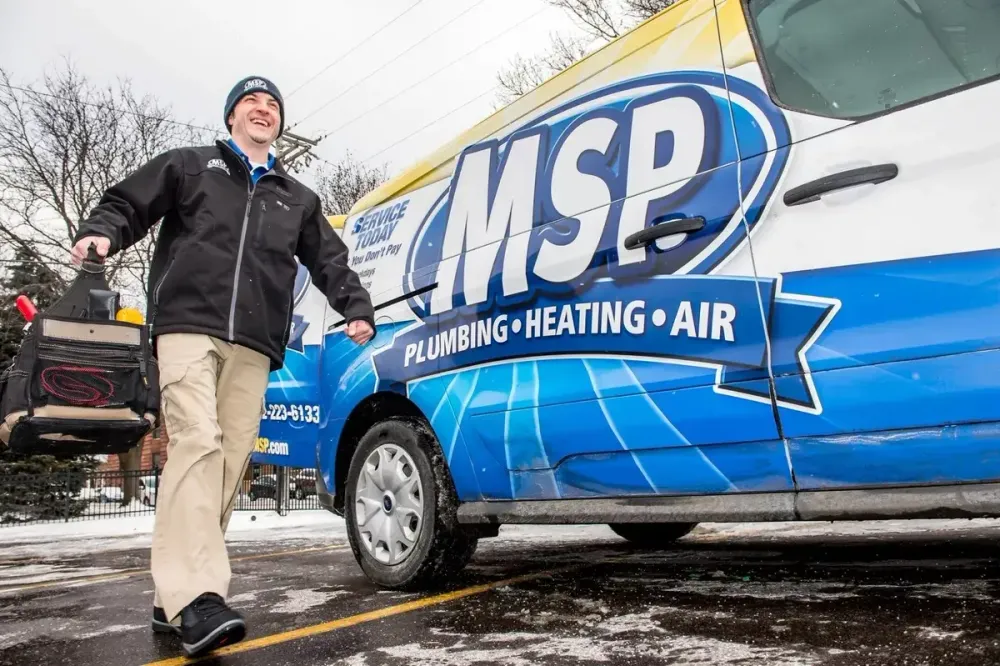 MSP technician standing beside a service van in winter