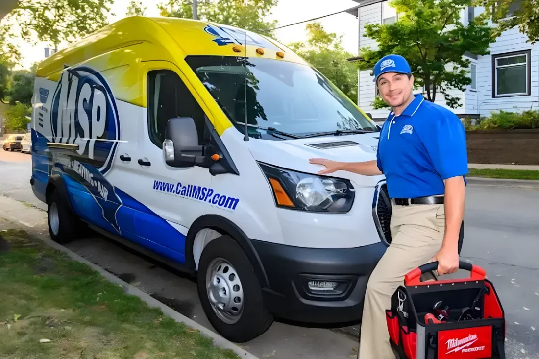 MSP technician with a tool bag beside a service van