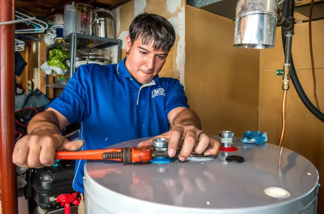 MSP technician using a wrench on a water heater