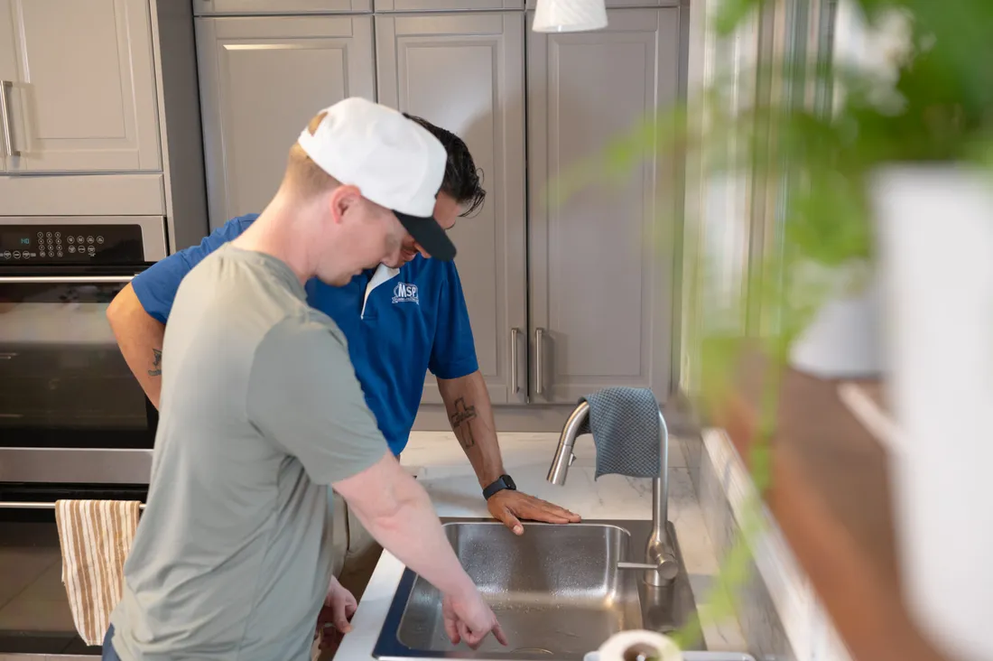 MSP technicians working at a kitchen sink