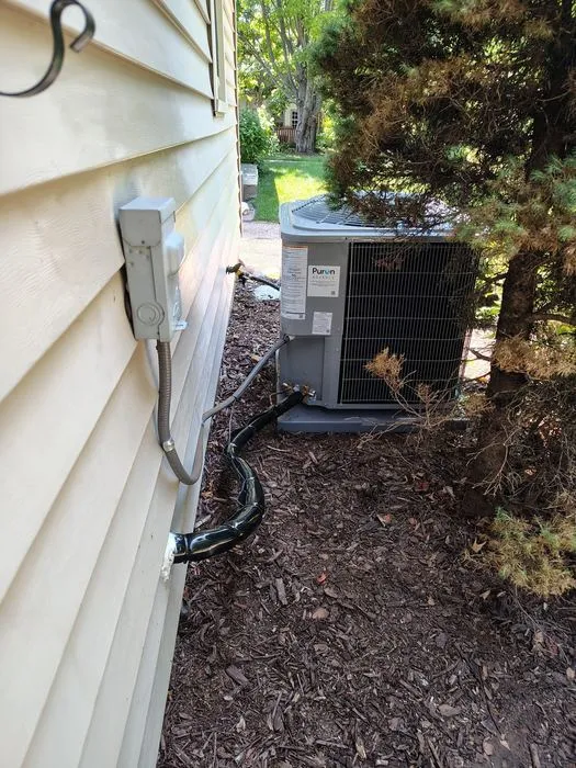 Outdoor air conditioner condenser beside a house