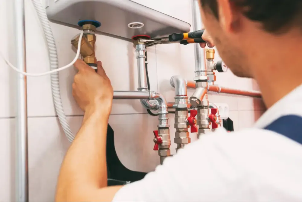 Plumber checking water heater pipe connections
