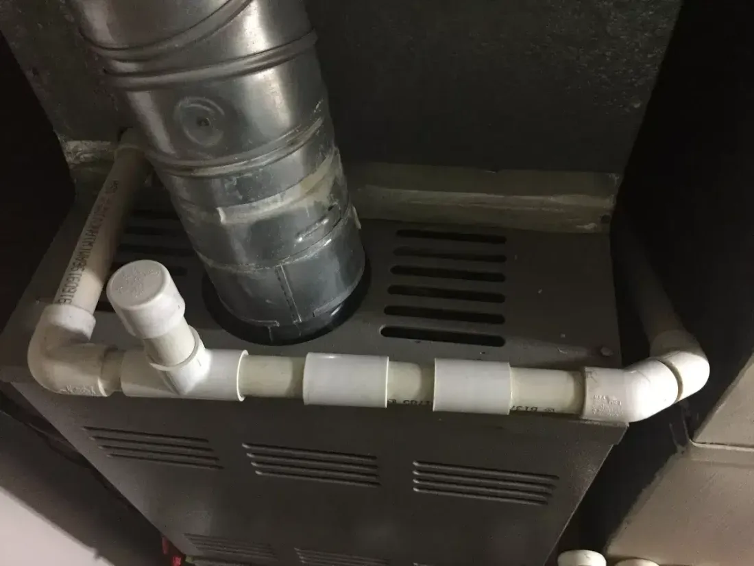 PVC condensate drain line connected to an HVAC unit