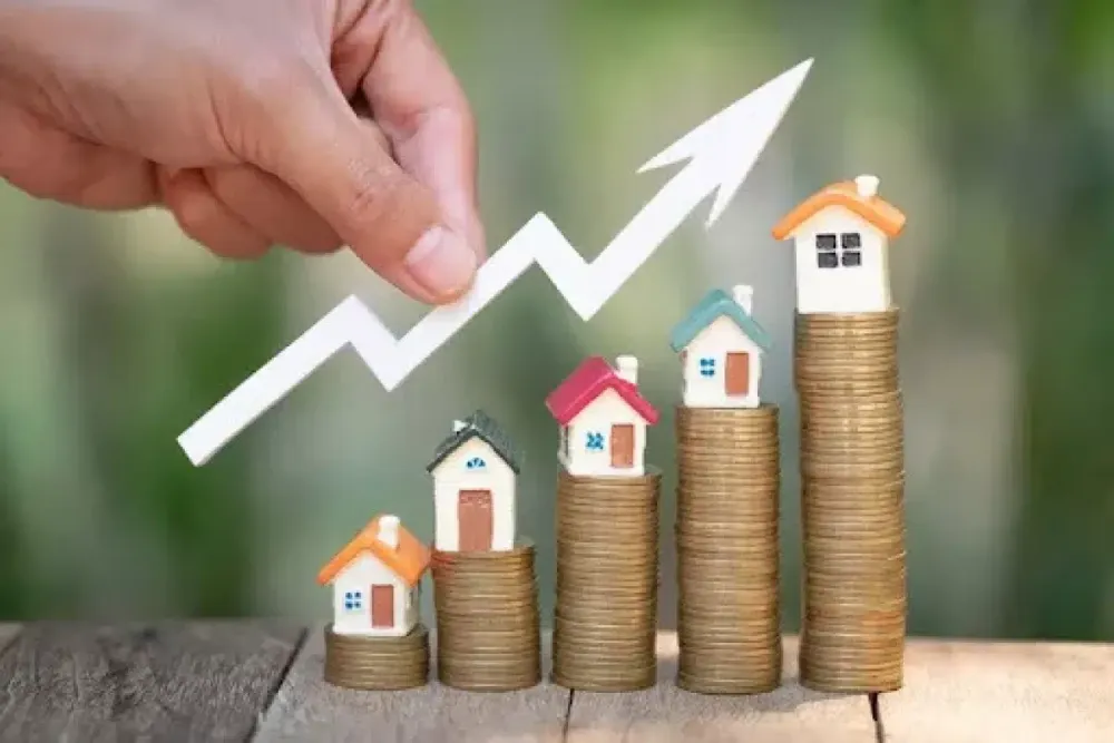 Small houses on stacks of coins with an upward arrow