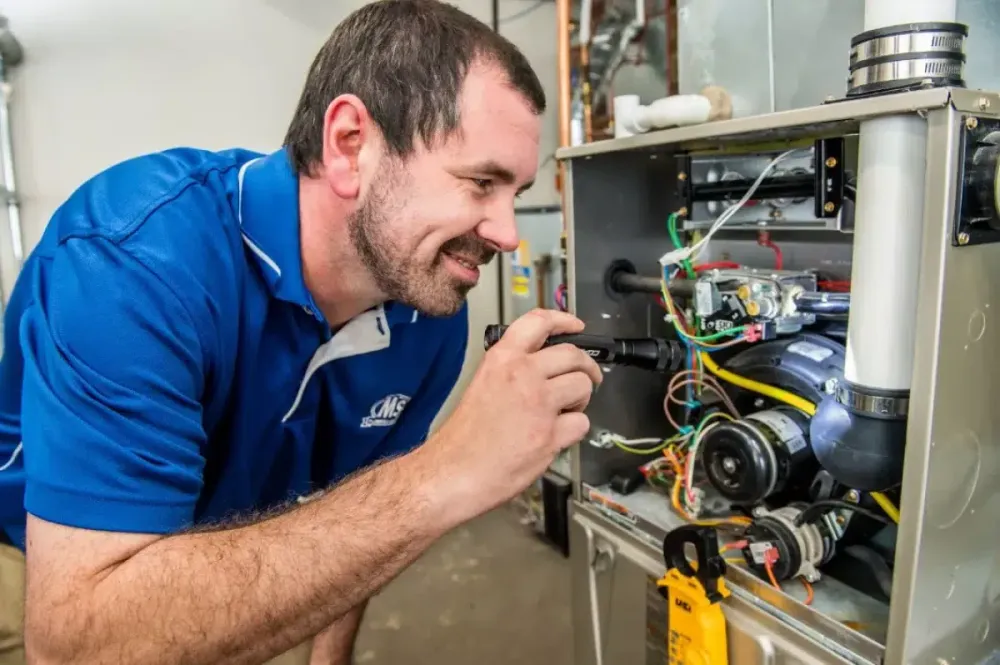 Technician inspecting furnace components