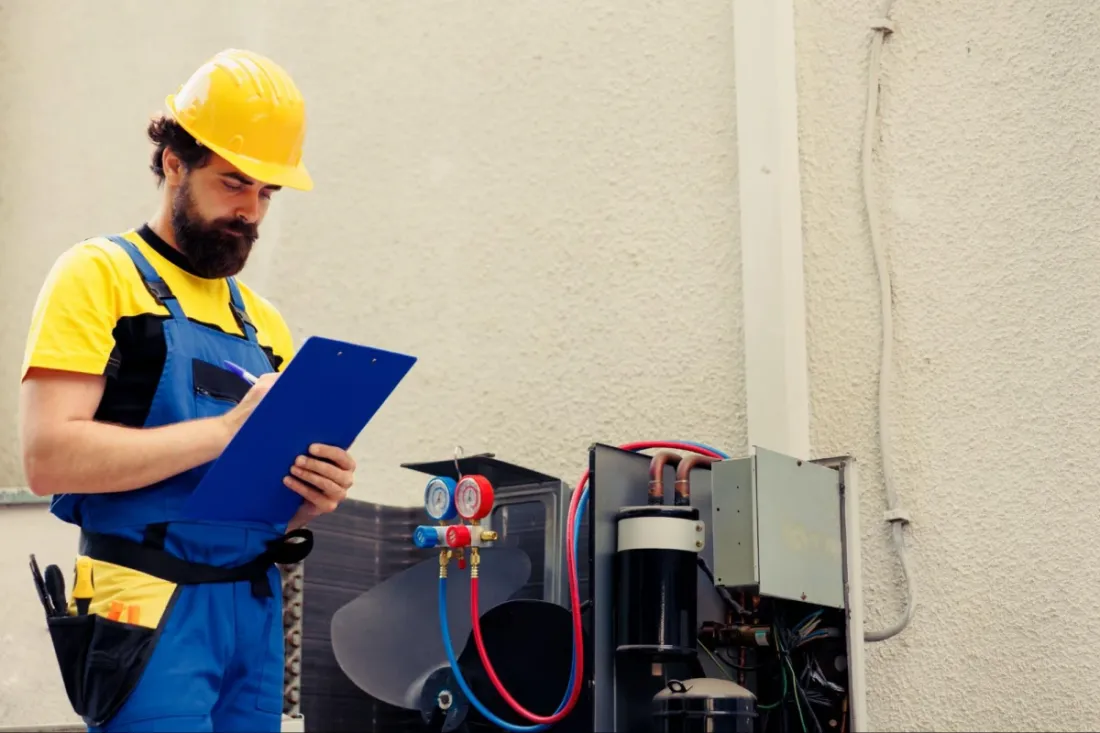 Technician inspecting HVAC equipment with a clipboard