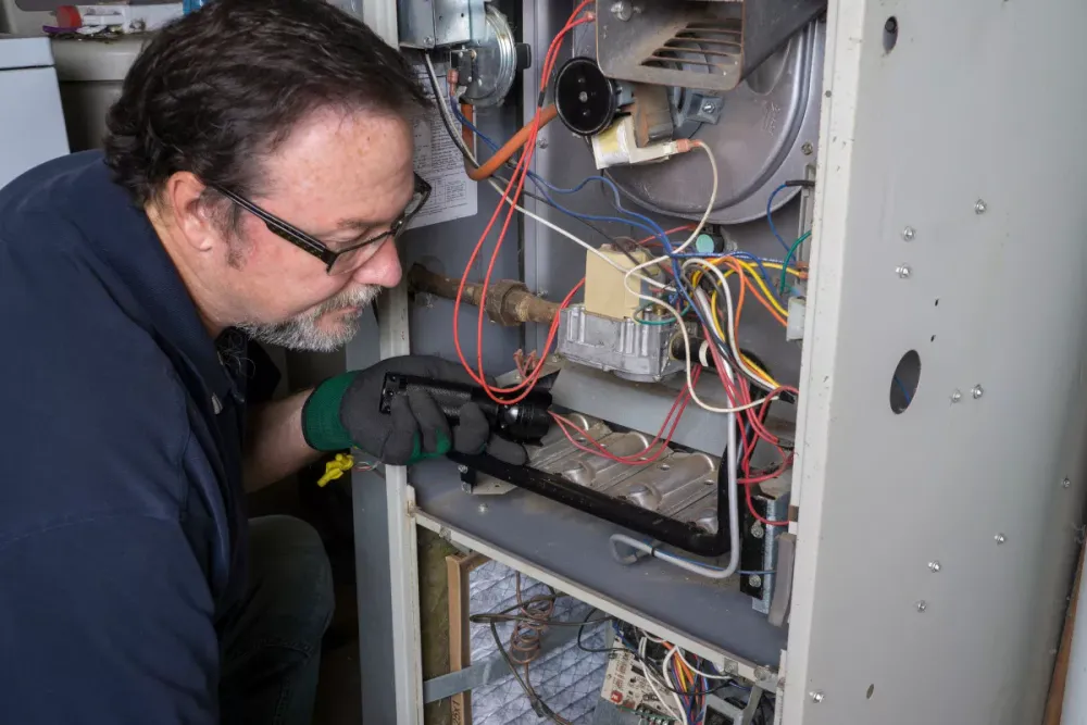 Technician inspecting an open furnace