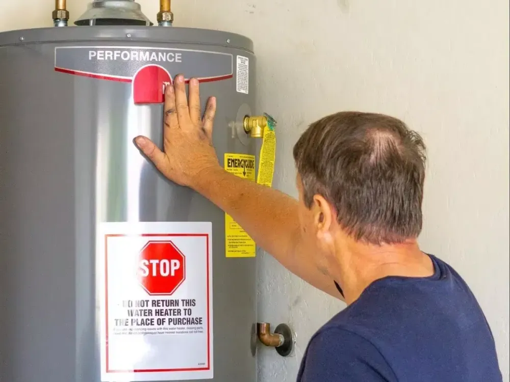 Technician inspecting a Rheem tank water heater