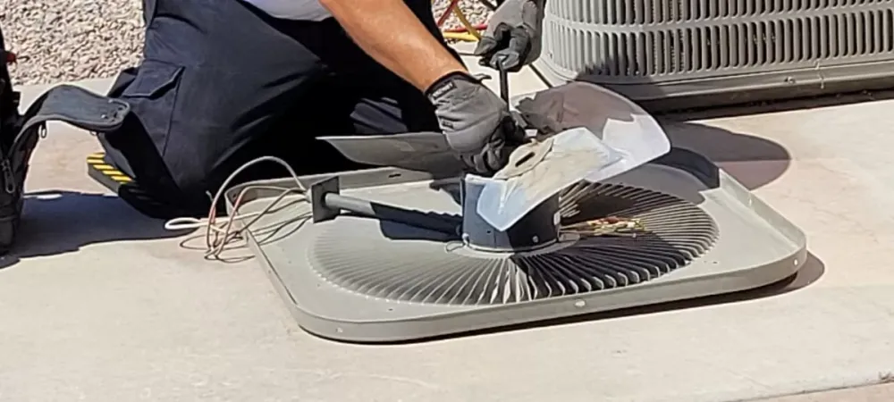 Technician working on an air conditioner fan assembly