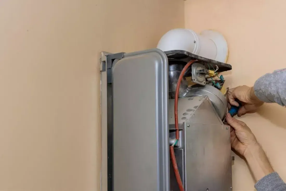Technician working inside a gas boiler