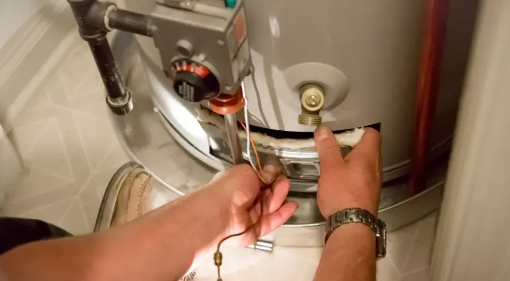 Technician working on a water heater burner assembly