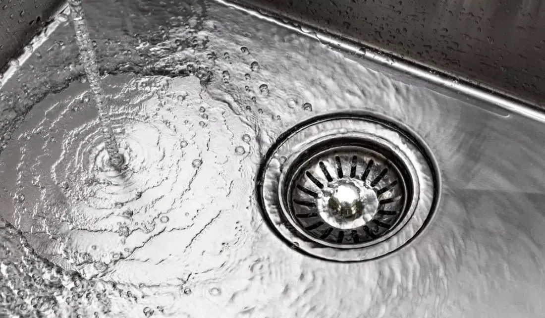 Water flowing toward a kitchen sink drain