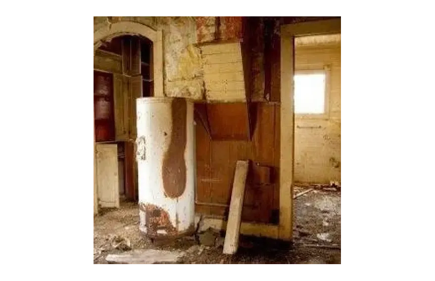 Water heater standing amid damage inside a home