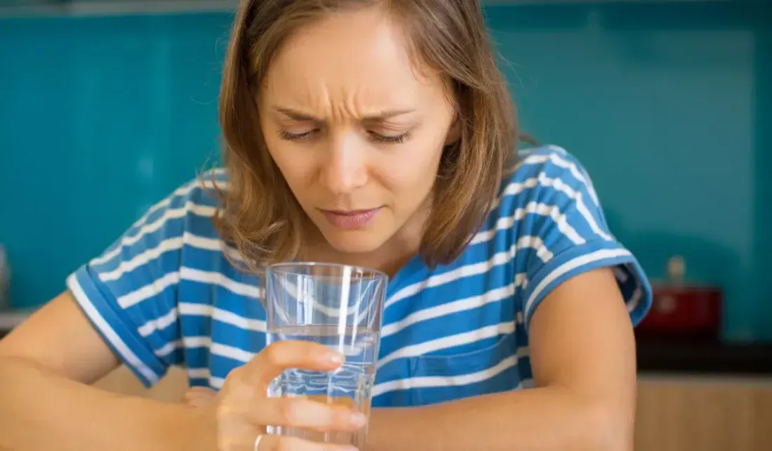 Woman inspecting a glass of drinking water