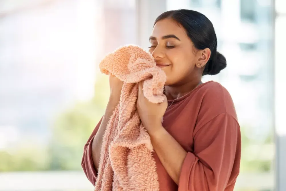 Woman smelling a clean towel