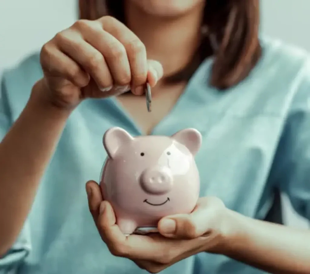 Person putting coin into piggy bank