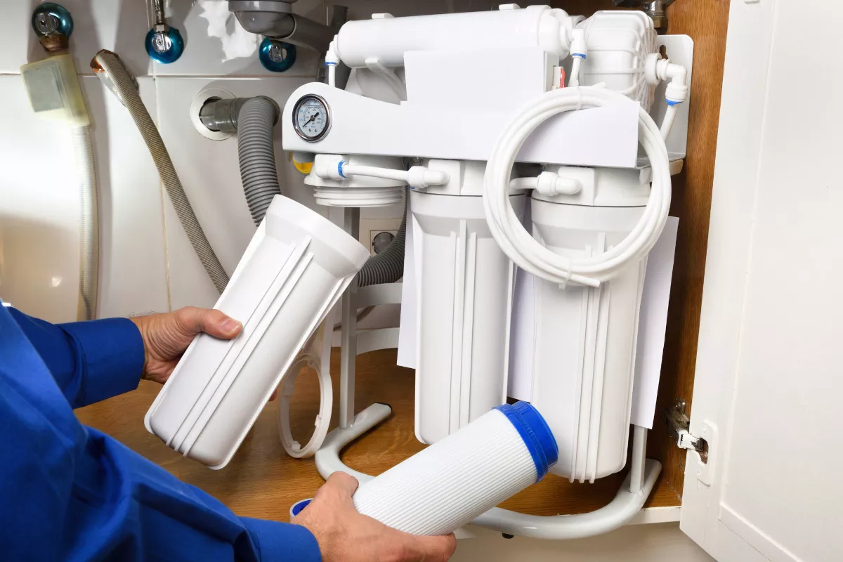 A person changing water filters 